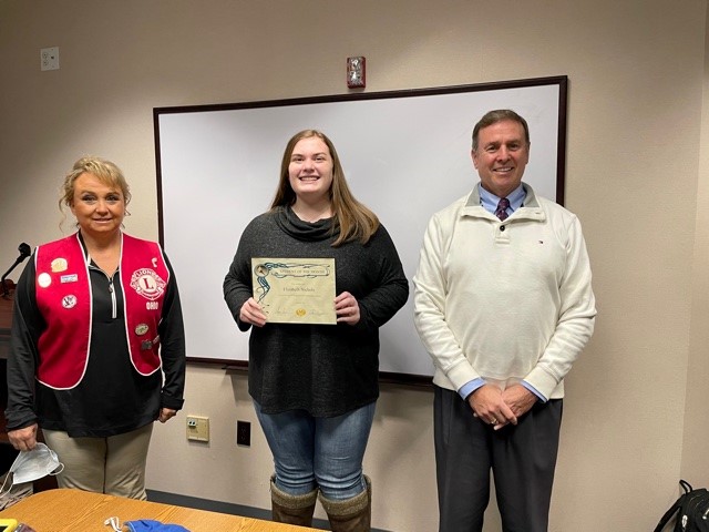 three people, one is holding a certificate